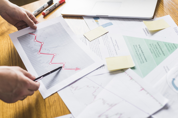 كيف يساهم استثمار القطاعات في تحقيق رؤية قطر الوطنية 2030 ؟ businessperson s hand analyzing increasing graph 23 2147838592 - كيف يساهم استثمار القطاعات في تحقيق رؤية قطر الوطنية 2030 ؟